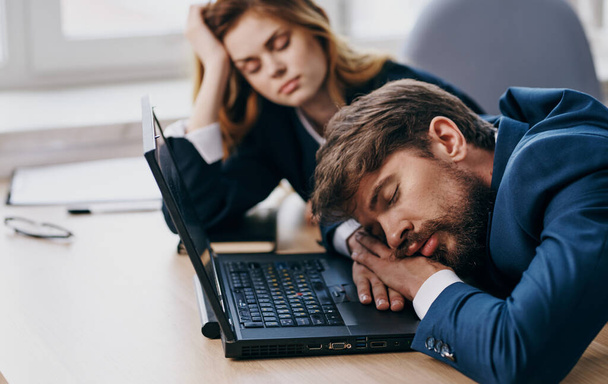 仕事仲間はノートパソコンの疲労回復の前の机で眠っている - 写真・画像