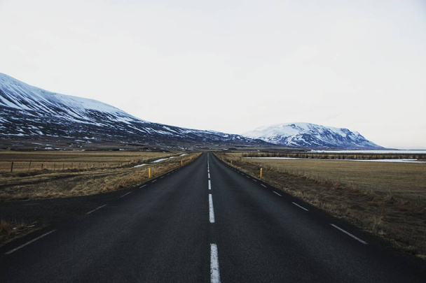 Panoramablick auf die typische leere isländische Asphaltautobahn Ring Road Golden Circle im schneereichen Winter Island - Foto, Bild
