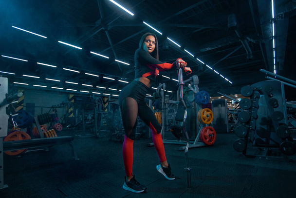 筋肉の若いフィットネススポーツ女性フィットネスジムでのバーベル付きワークアウト. - 写真・画像