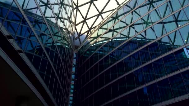Edificio futurista urbano, diseño de centro de negocios contemporáneo. Moderno edificio de oficinas, fachada de cristal con patrón azul geométrico. Vista del ángulo inferior - Metraje, vídeo