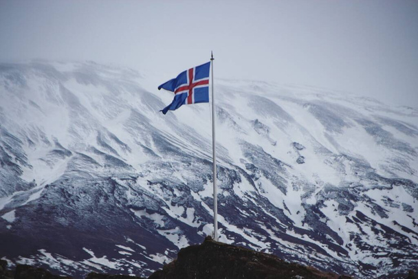 Szczegóły zbliżenie islandzkiej flagi narodowej baner symbol znak śnieg zima góry Thingvellir Park Narodowy Islandia - Zdjęcie, obraz