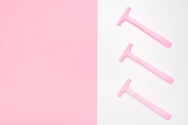 Pink disposable plastic woman razor blade for shaving, body care and unwatred hair removing on legs, armpits and face, flat lay with copy space - Fotó, kép
