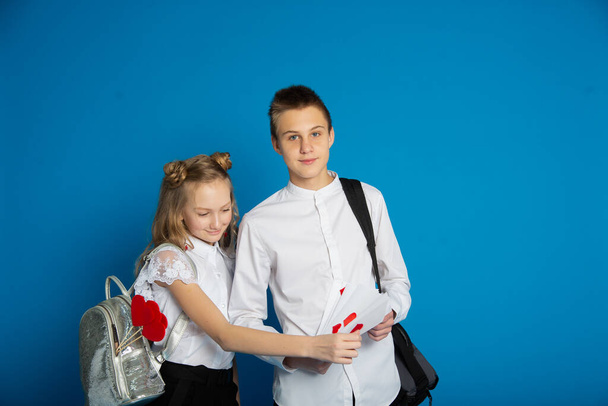 A couple of schoolchildren are teenagers on Valentine's Day on a blue background - Fotografie, Obrázek