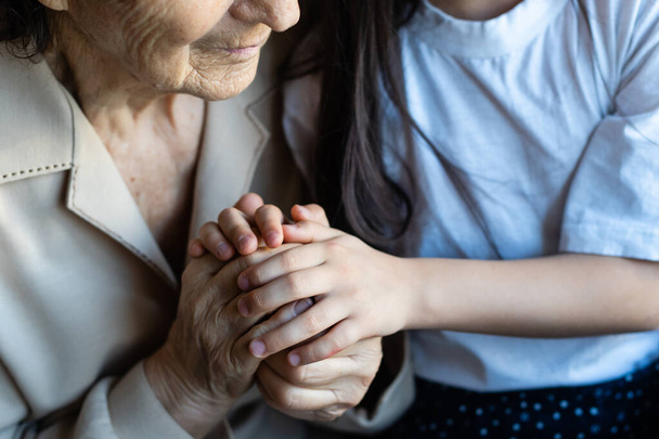 very elderly great-grandmother and granddaughter hold hands - Photo, image