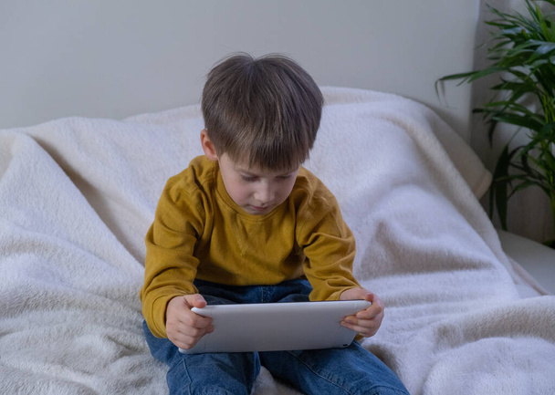 Kommunikation mit Verwandten und Freunden online. Kleiner Junge trifft sich und spricht im Videochat während der Coronavirus-Pandemie.  - Foto, Bild