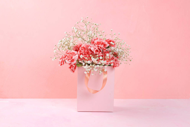 Goździki w różowym pudełku, abstrakcyjne wiosenne tło kwiatowe. Kreatywny nowoczesny bukiet, minimalna koncepcja wakacyjna. Pocztówka dla kobiet dzień lub dzień matki, wszystkiego najlepszego, ślub, baner na ekranie, - Zdjęcie, obraz