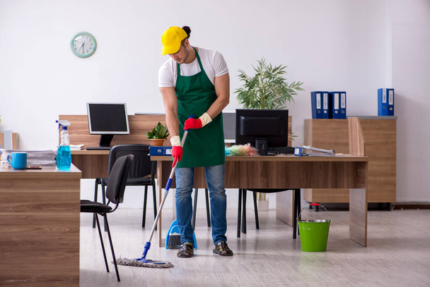 事務所を掃除する若い男の請負業者 - 写真・画像