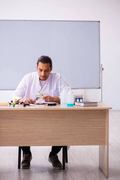 Young male chemistry teacher in the classroom - Fotó, kép