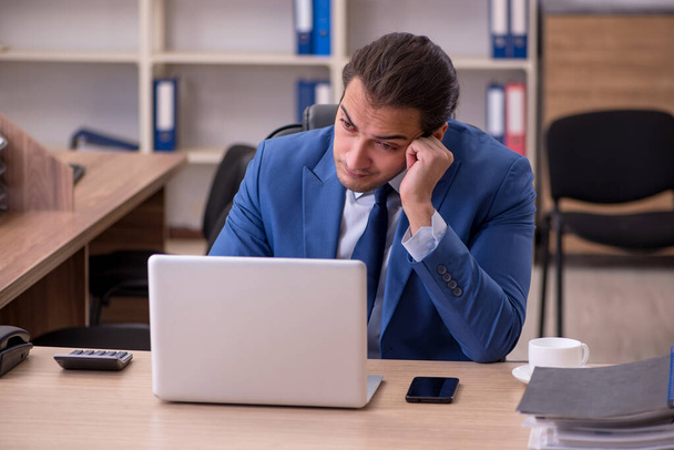 Young sick businessman employee suffering at workplace - Photo, Image