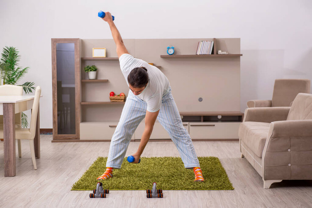 Young man doing sport exercises at home - Foto, imagen