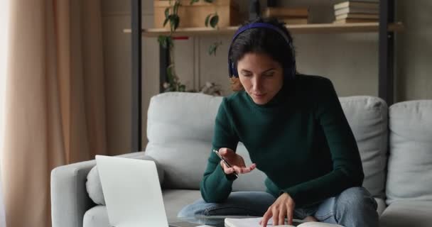 Woman wear headphones talking to online tutor using laptop app - Video