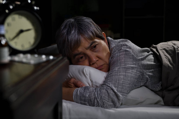 Depressed senior woman lying in bed cannot sleep from insomnia - Photo, Image