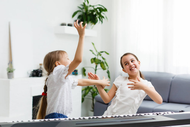 Home lesson on music for the girl on the piano. The idea of activities for the child at home during quarantine. Music concept - Photo, Image