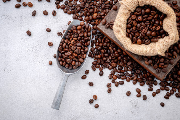 Roasted coffee beans with scoops setup on white concrete background. - Photo, Image