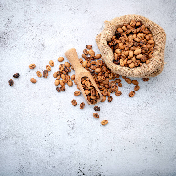 Roasted coffee beans with scoops setup on white concrete background. - Photo, Image