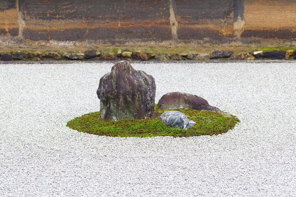 京都・龍安寺の禅ロックガーデン。日本。庭には白い砂利の上に15個の石がある.  - 写真・画像