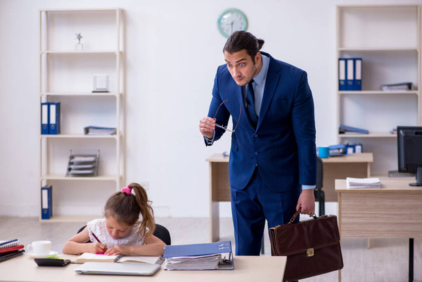 Jonge mannelijke werknemer en zijn kleine meisje in het kantoor - Foto, afbeelding