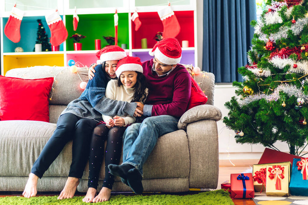 Portret szczęśliwej rodziny azjatyckiej ojciec i matka z córką w kapeluszach Mikołaja zabawy patrząc w kamerę i ciesząc się spędzaniem czasu razem w czasie Bożego Narodzenia w domu - Zdjęcie, obraz