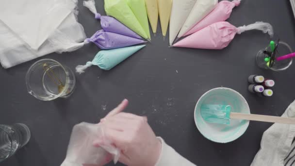 Příprava potrubí tašky s barevným máslovým polevou zdobit jednorožec téma vanilkové cupcakes. - Záběry, video