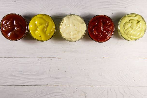 Set de salsas sobre mesa de madera blanca. Vista superior, espacio de copia - Foto, Imagen