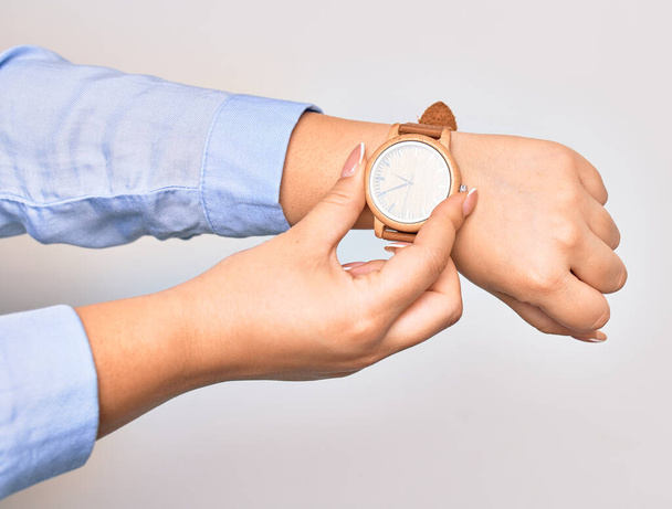 Mão de uma jovem empresária caucasiana a usar relógio de pulso. Relógio de captura com dois dedos sobre fundo branco isolado - Foto, Imagem