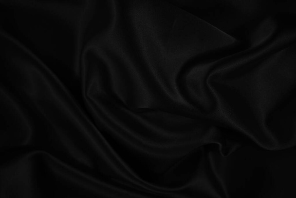Fondo negro de tela brillante. Fondo abstracto oscuro. Pliegues suaves ondulados en la tela. - Foto, Imagen