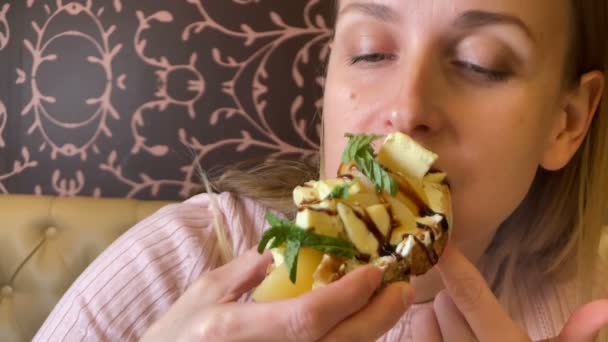 Női portré vegetáriánus szendvicset eszik a kávézóban - Felvétel, videó