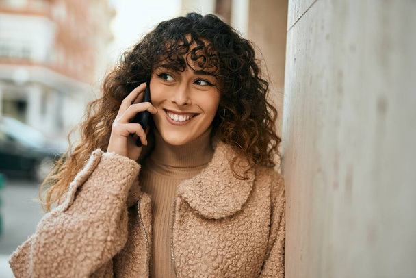 Young hispanic woman smiling happy talking on the smartphone at the city - Photo, Image