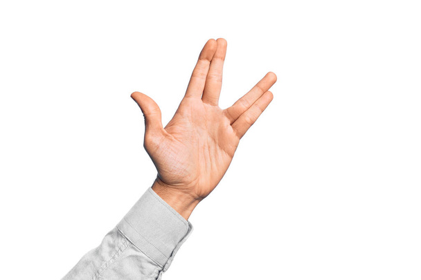 Ręka białego młodzieńca pokazuje palce na białym tle, pozdrawiając Wolkana, pokazując dłoń i palce, dziwaczną kulturę. - Zdjęcie, obraz