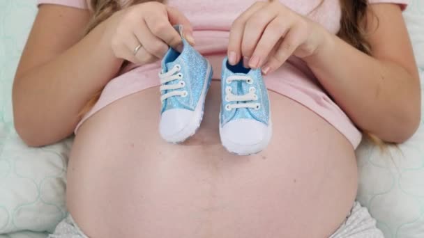Dança engraçada de pequenas botas de bebê na barriga grande mulher grávida Conceito de gravidez e esperando bebê - Filmagem, Vídeo