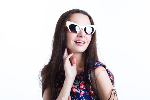 Close-up portrait of cute brunette woman in sunglasses and colorful dress, isolated on white. - Valokuva, kuva