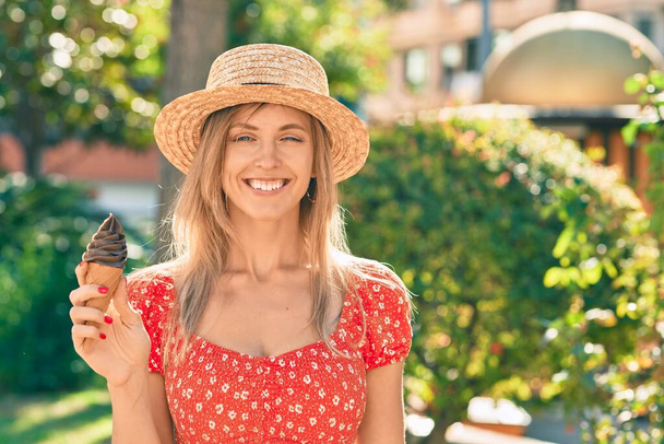 Jovem loira turista vestindo estilo de verão comendo sorvete no parque. - Foto, Imagem
