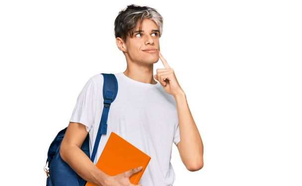 Young hispanic man wearing student backpack and holding books serious face thinking about question with hand on chin, thoughtful about confusing idea  - Foto, afbeelding