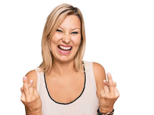 белая женщина средних лет в повседневной одежде показывая средний палец делает трахнуть вас плохое выражение лица, провокация и грубое отношение. Крики возбужденных  - Фото, изображение