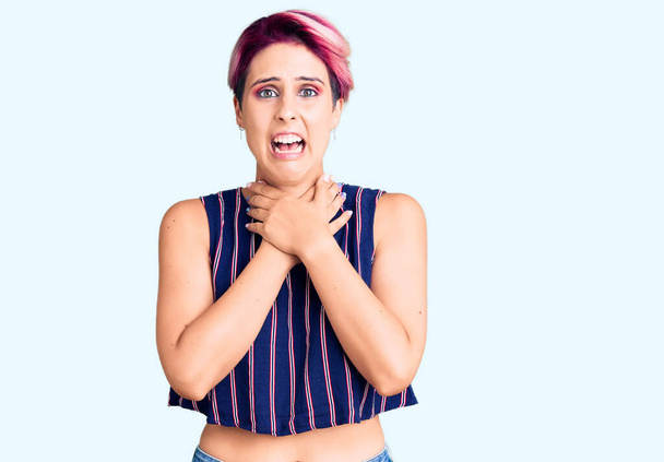 Young beautiful woman with pink hair wearing casual clothes shouting and suffocate because painful strangle. health problem. asphyxiate and suicide concept.  - Fotoğraf, Görsel