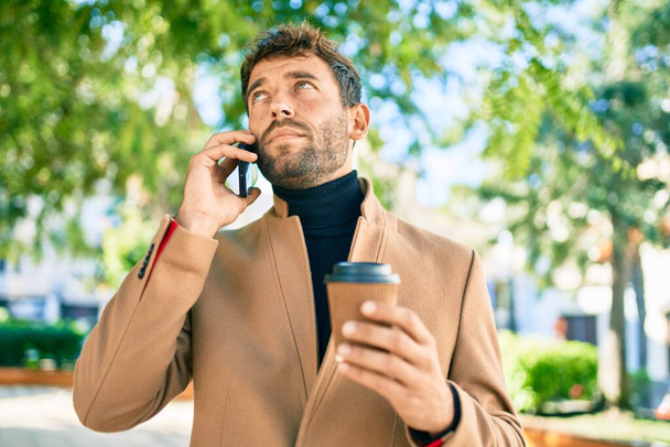 Handsome business man wearing elegant jacket using smartphone outdoors - Φωτογραφία, εικόνα