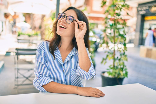 Young hispanic businesswoman smiling happy sitting at coffee shop terrace. - Φωτογραφία, εικόνα