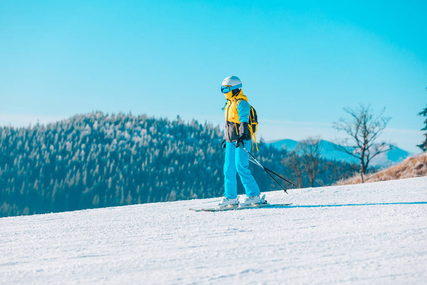 Kadın arka planda kış yamaçlarında kayak yapıyor. - Fotoğraf, Görsel