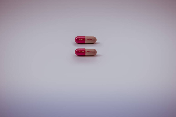 Colorido Covid 19 (Vírus Corona / Sars- cov-2) pílulas a ler "Fique em casa, ficar seguro" isolado em fundo branco com espaço de cópia Medicação para prevenção, imunização e tratamento de vírus - Foto, Imagem