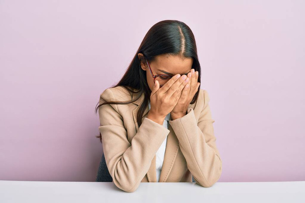 Beautiful hispanic woman working at the office with sad expression covering face with hands while crying. depression concept.  - Fotografie, Obrázek