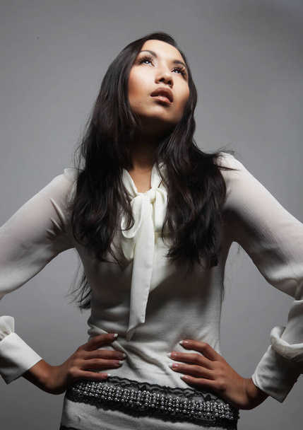 Fashion and people concept: Beautiful young asian woman model with long hair posing in fashionable white dress - Fotó, kép