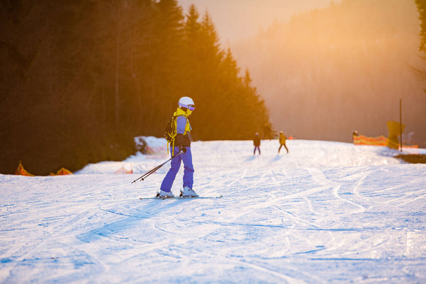 mujer esquiando al atardecer copia de la estación de esquí - Foto, imagen