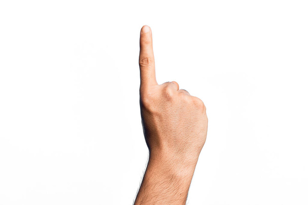 Mão de jovem caucasiano mostrando dedos sobre fundo branco isolado contando número um usando dedo indicador, mostrando ideia e compreensão - Foto, Imagem