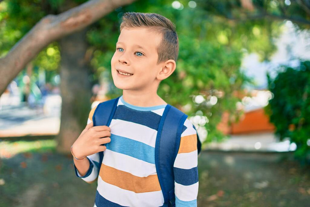 dorable valkoihoinen opiskelija poika hymyilee onnellinen seisoo puistossa. - Valokuva, kuva