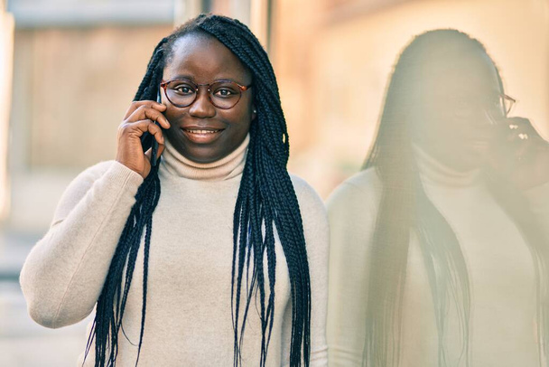 Giovane donna afroamericana che parla sullo smartphone in città. - Foto, immagini