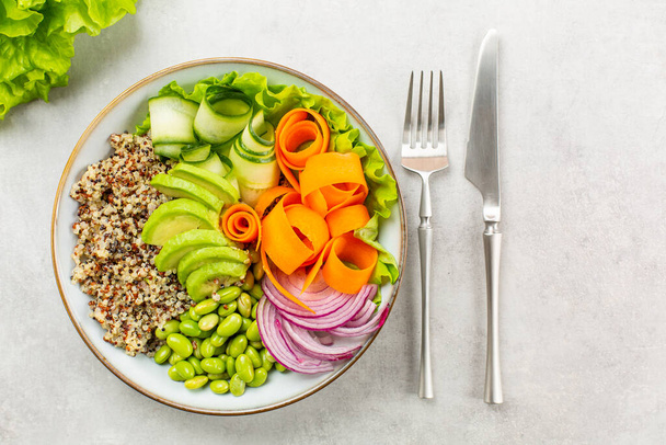 Boeddha schaal - gezond en evenwichtig voedselconcept. Quinoa, edamamebonen, avocado, ququmber, wortel, rode ui en groene salade. Kopieerruimte. - Foto, afbeelding