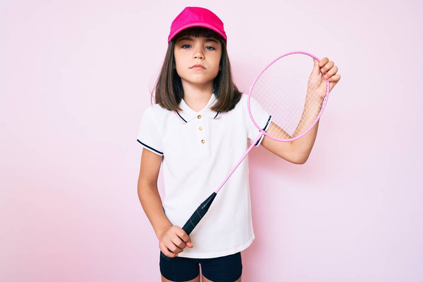 Young little girl with bang holding badminton racket relaxed with serious expression on face. simple and natural looking at the camera.  - Foto, Imagem
