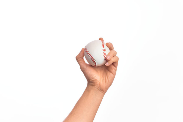 Mano di giovane caucasico che tiene palla da baseball su sfondo bianco isolato - Foto, immagini