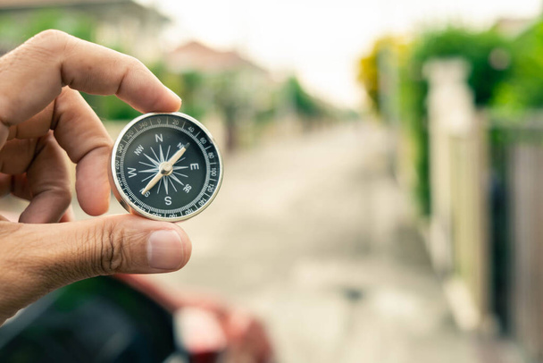 Man hand houden kompas op stad en auto wazig achtergrond Met behulp van behang of achtergrond reizen of navigator afbeelding. - Foto, afbeelding