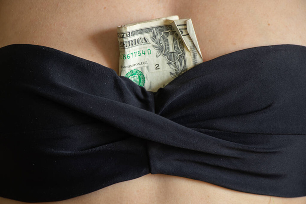 billets d'un dollar dans un soutien-gorge d'une jeune fille gros plan - Photo, image